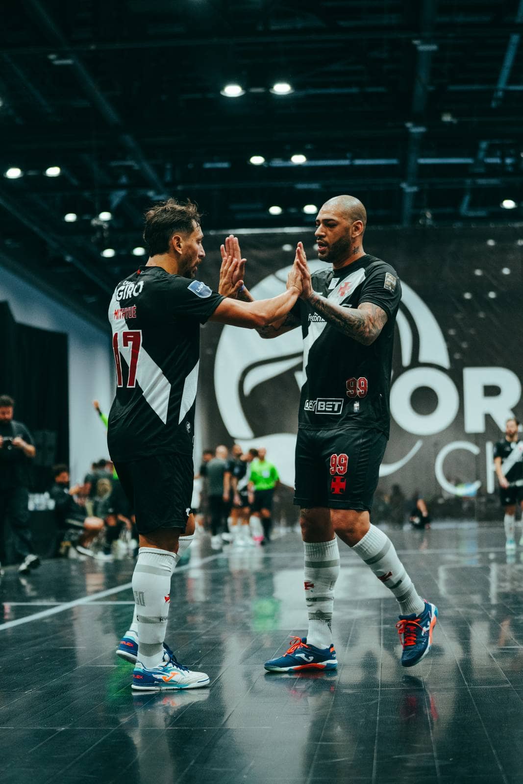 Two teammates slap hands on the court