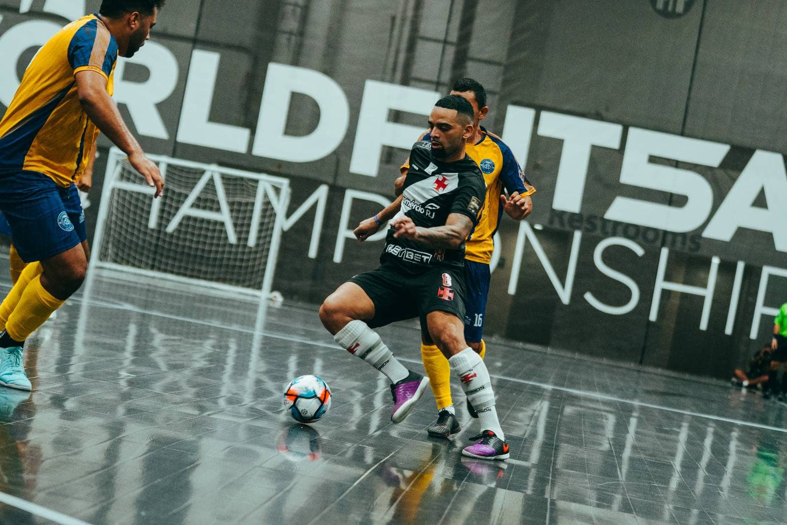 A player shields the ball with two defenders closing in