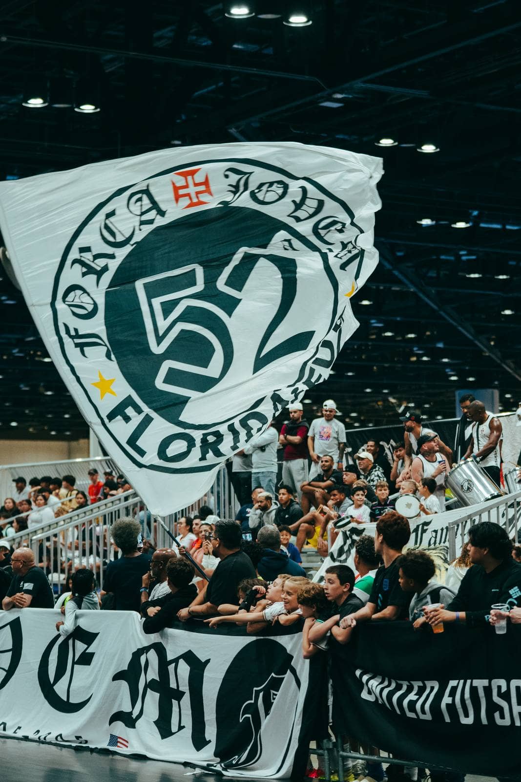 A club flag is waved above the stand