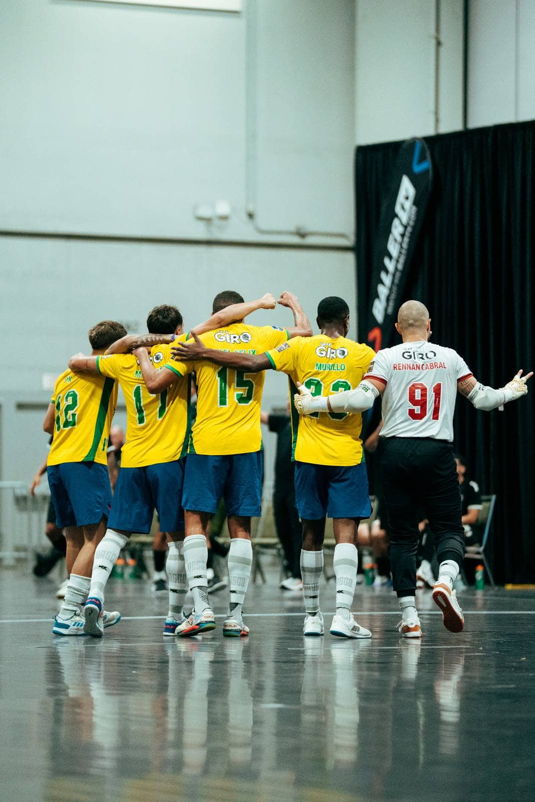 Teammates link arms as they walk back across the court