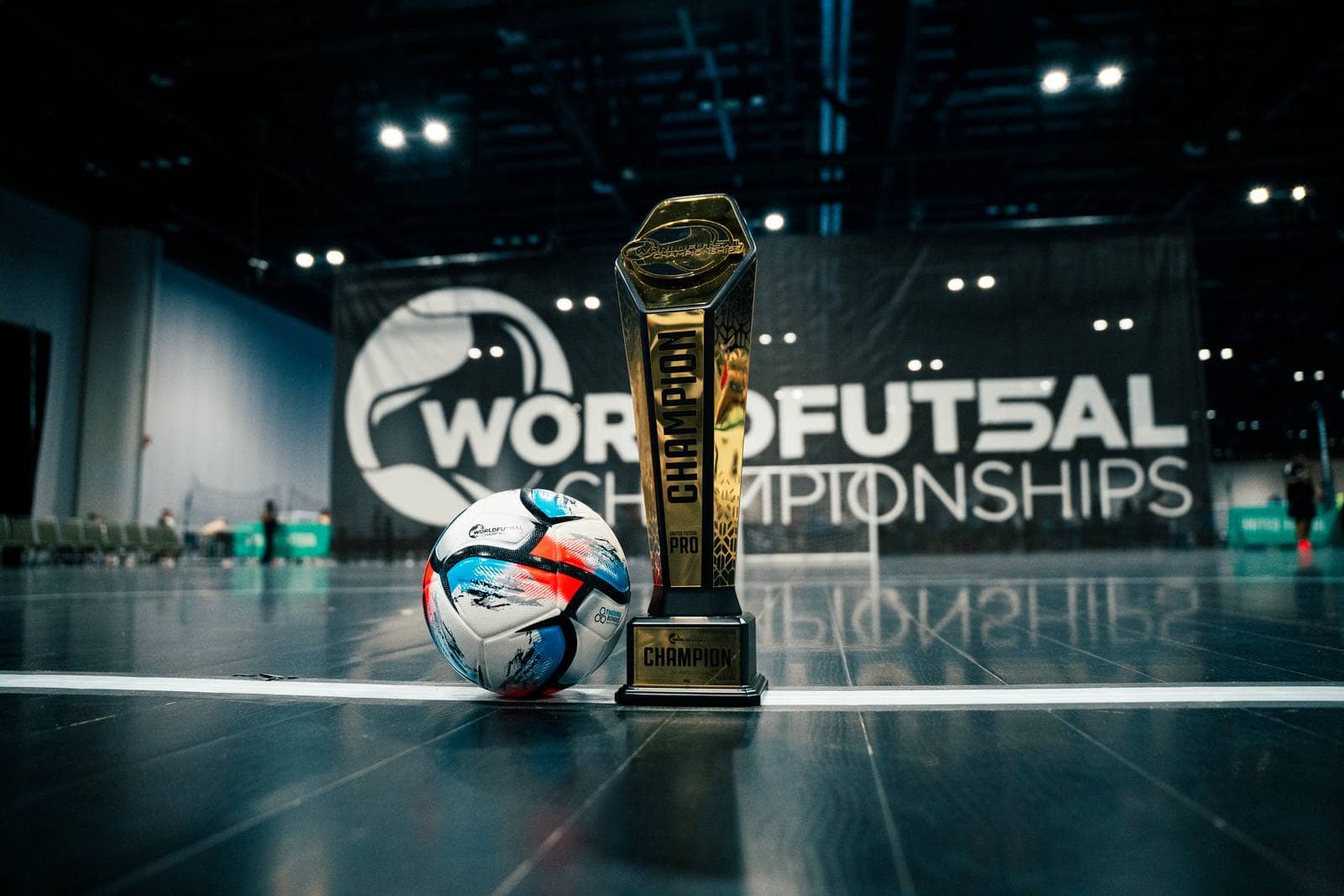 The trophy sits on the court beside a match ball