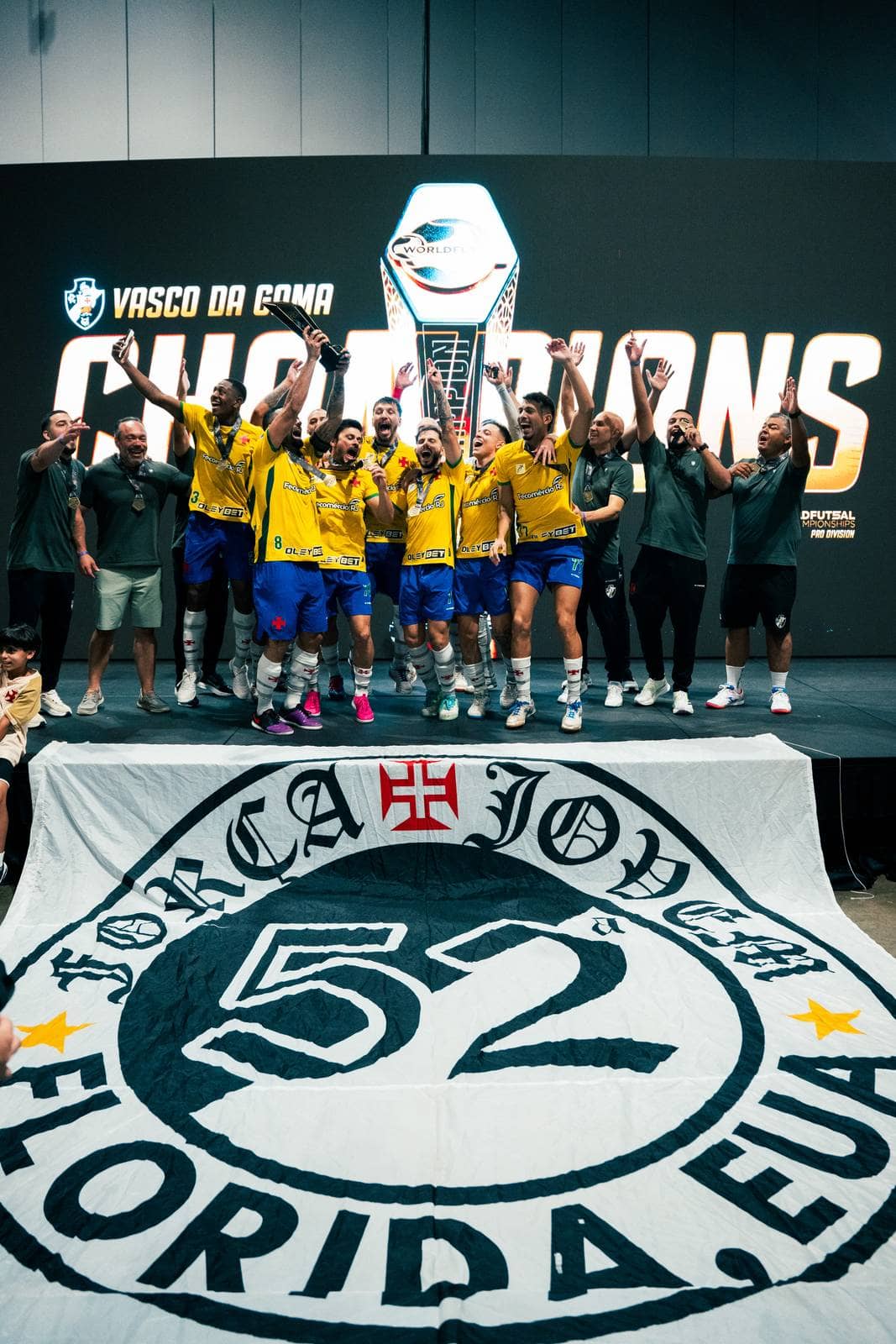 The champions lift the trophy on stage